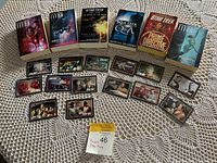 Seven Star Trek novels and eighteen trading cards on a white lace tablecloth.