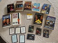 William Shatner Star Trek novels and Star Trek collectible cards on a fabric surface.