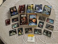 Overview photo showing seven Star Trek novels arranged in rows along with nine vintage Star Trek trading cards on a white lace tablecloth.