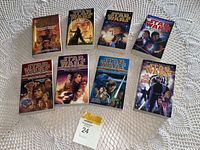 Image of nine Star Wars paperback novels arranged on crocheted cloth showing cover art of multiple Star Wars characters.