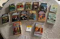 Photo of 15 Terry Brooks novels including various Shannara series titles laid out on a round white table with a lace cloth.