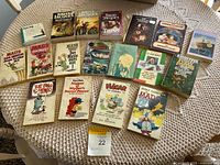 Photo of 19 vintage books laid out on table including MAD Magazine, Brian Jacques' Redwall series, Hardy Boys, and other children's books