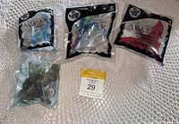 Top view of four sealed McDonald's toys on a lace surface showing three Avatar series and one Incredible Hulk toy in original packaging.