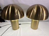 Pair of two mushroom design table lamps with faux brass finish on metal body, front view showing their shape and size.