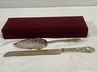 Full set showing the cake knife and cake server along with maroon presentation case