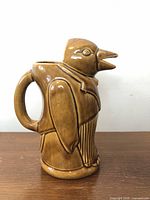 Side view of the ceramic penguin pitcher showing the molding detail, beak spout, and handle integrated into the penguin’s back.