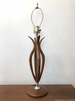 Full view of vintage wooden lamp with curved wooden pieces and brass socket