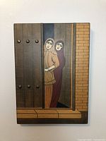 Full view of the rectangular wooden plaque with female figures painted on the wood panels