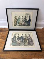 Two framed Godeys fashion prints leaning against wall, showing full view of both prints and frames