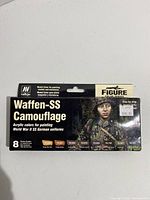 Front view of Acrylicos Vallejo Waffen-SS Camouflage miniature painting set box showing brand, product series, and image of soldier in camouflaged uniform.