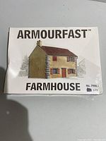 Front of the sealed Armourfast Farmhouse model kit box showing brand, model name, scale, and illustration of assembled farmhouse.