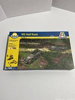 Front view of boxed model kit featuring two M3 Half Track vehicles in a realistic outdoor military scene, Italeri branding and scale information visible