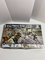 Front of the box showing Italeri Pegasus Bridge Airborne Assault model kit with 75th Anniversary D-Day branding and artwork depicting a WWII scene on the Pegasus Bridge.