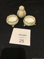 Group view of two footed salt cellars and pepper shaker