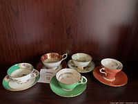 Group shot of five teacup and saucer sets on shelf
