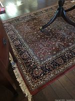 Corner of rug showing red field, navy border, fringe