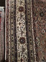 Section of rug showing central beige panel with floral motifs and side borders