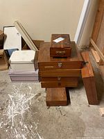 Stack of six boxes including wooden and cardboard boxes in various sizes