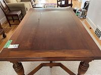 Top view of the vintage wooden dining table showing the main surface and legs.