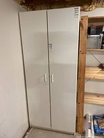 Photo of white pantry cabinet with two doors closed, showing overall condition and design.