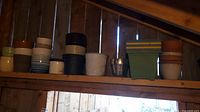 Shelves showing a variety of garden pots in assorted shapes, sizes, and colors including ceramic and plastic materials.