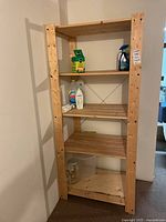 Frontal view of wooden 5-tier storage shelf with items placed on some shelves.