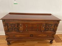 Full front view of buffet showing overall shape, carved doors, drawers and turned legs