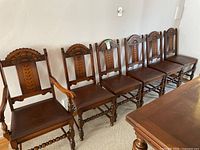 Group of six chairs in a row beside a dining table