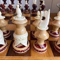 Close-up of carved ivory-tone queen, rook, bishop, knight bases on board