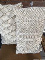 Front view of both cream wool textured pillows