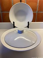 Both Athena bowls, lid shown on front bowl, open bowl on stand behind