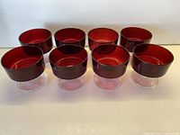 Front view of eight ruby red dessert bowls on clear stems
