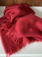 Folded deep coral mohair-wool throw showing overall look and fringe