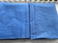 Both folded blue wool blankets showing centre stripes and edging