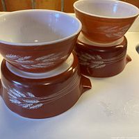 Four Pyrex Autumn Harvest bowls stacked to show two handled casseroles and two mixing bowls