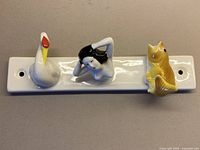 Front view showing swan, woman, fish figures on plaque