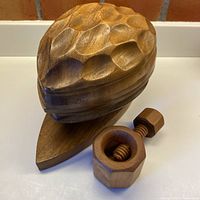overview of carved nut-shaped bowl on base with screw nutcracker