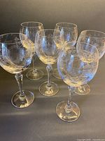 All six etched crystal wine glasses standing