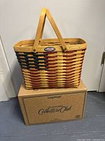 Front and side views of the Longaberger large woven basket with American flag design, showing wooden handles and metal badge.