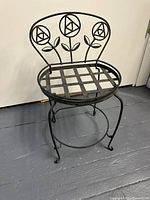 Photo showing full metal plant stand with chair-style seating, lattice seat, and floral backrest design.