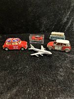 Group photo showing all five die cast and model items together on black background for size comparison