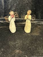 Two Willow Tree angel figurines on black fabric background, showing overall lot contents