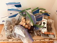 Plastic bags containing various vintage handles and drawer pulls, showing quantity and mix.