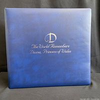 Blue binder with gold embossed text stating 'The World Remembers Diana, Princess of Wales'