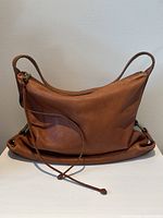 Front view of the soft cognac leather Banana Republic bag showing zipper and strap detail.