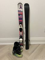 Front and back view of Atomic Vantage Girl 100 skis with bindings and Dalbello Menace ski boots.