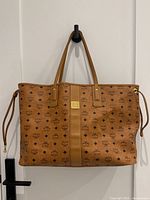 Front view of bag with Visetos monogram canvas, double handles, central nappa leather panel and gold-tone logo plaque