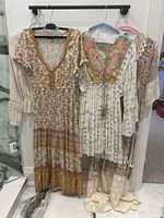 Three boho garments on hangers displayed against white wall