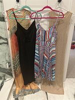Wide shot of four summer dresses hung side by side