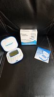 Weight Watchers Points Plus Calculator device open with display screen visible, original retail box, and instruction manual on a black surface